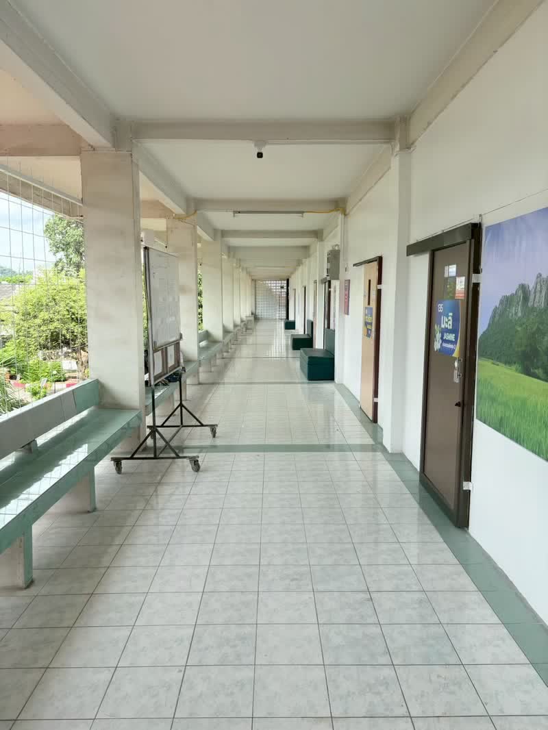 ทางเดินหน้าห้องพักที่ติดภาพทุ่งนาขนาดใหญ่และป้ายชื่อห้อง